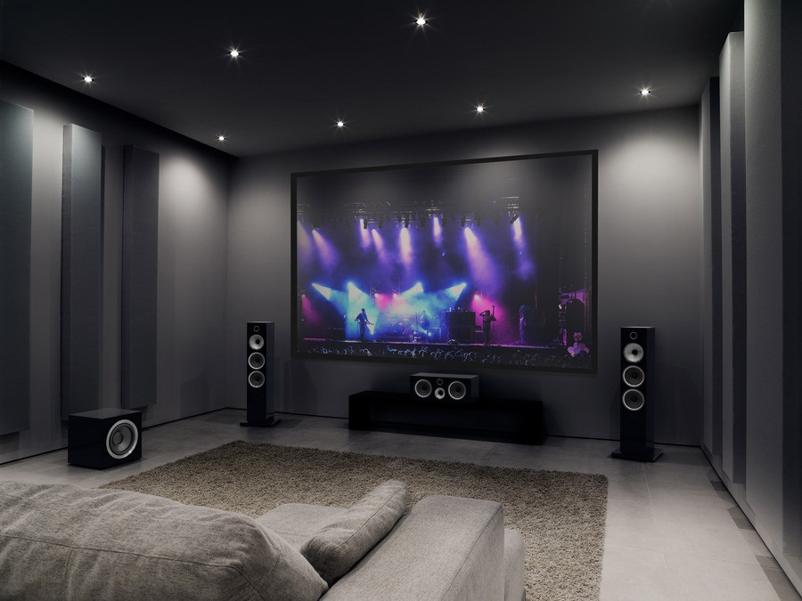 A home theater system with dark gray walls and floor-standing speakers.