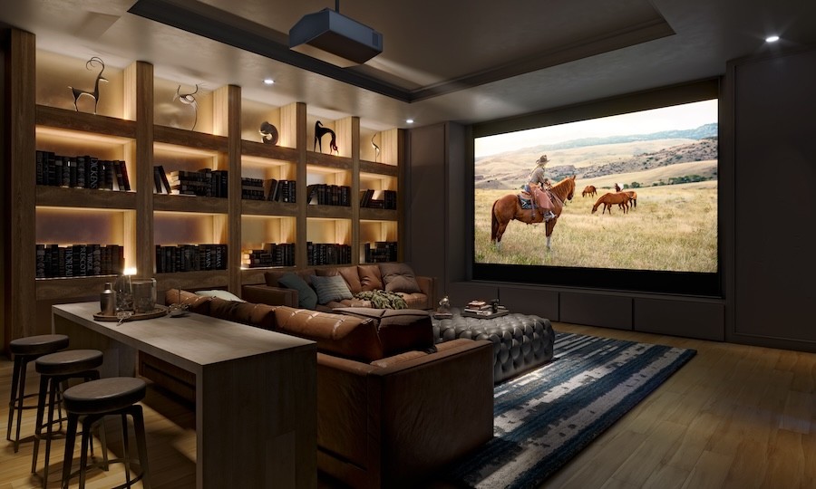 A cozy, warm-toned home theater with a built-in bookshelf along one wall and a screen depicting a scene from a western.