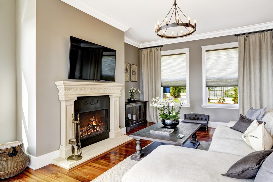 A luxury living room with a fireplace, large couch, and flat-screen TV.