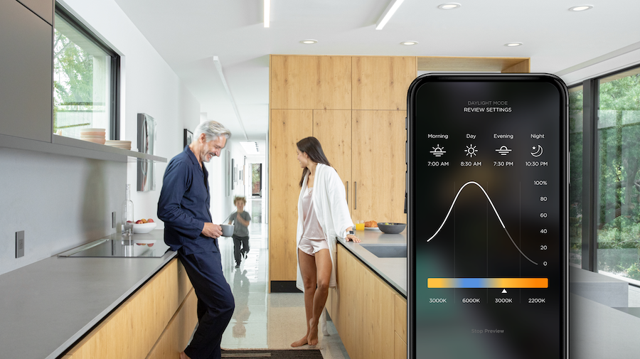  A family in the kitchen looks at light settings on a Savant mobile app.