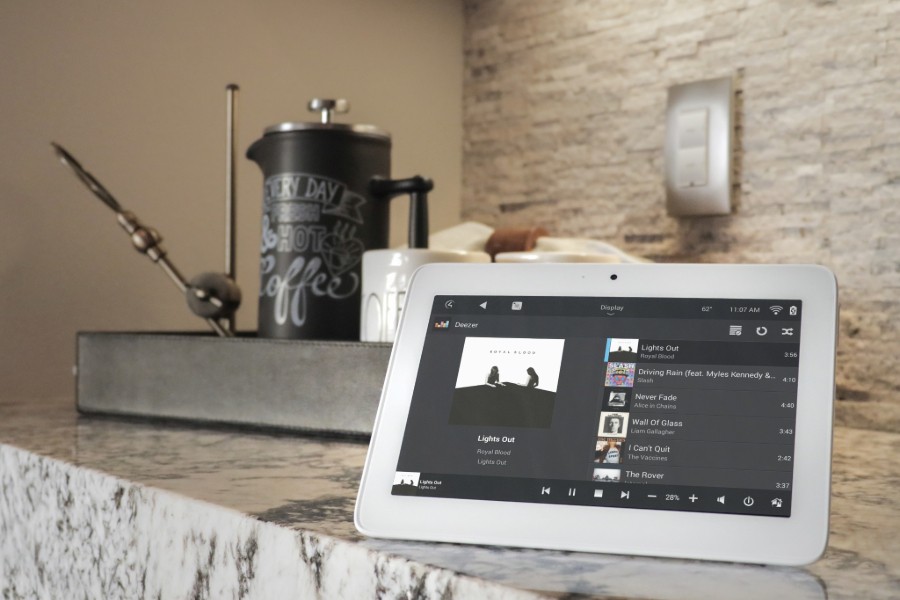 A tablet placed on a countertop, showcasing a music playlist on Deezer.