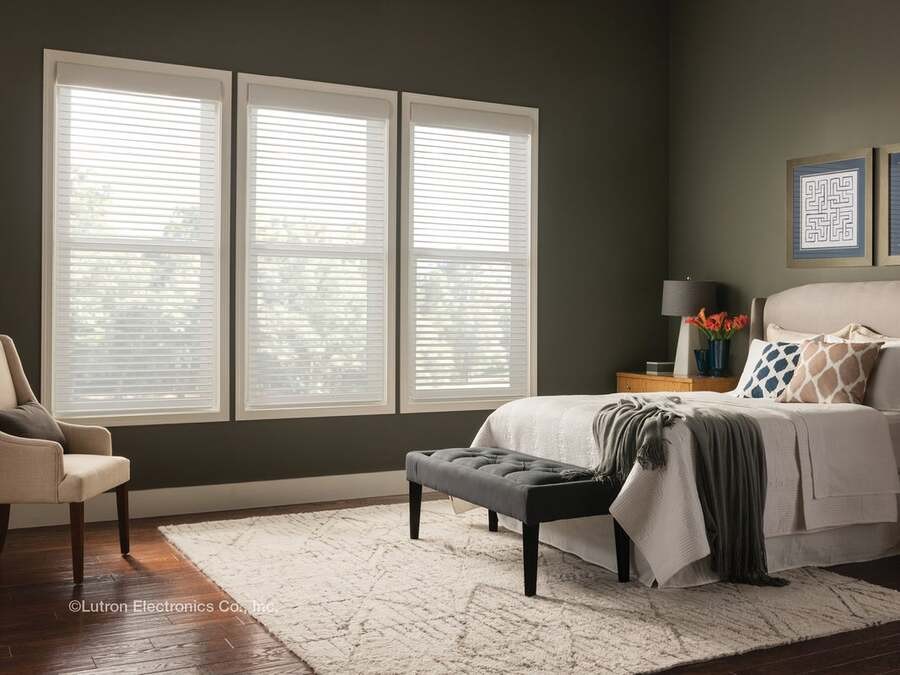 A luxury bedroom has sheer shades by Lutron that let sunlight in.
